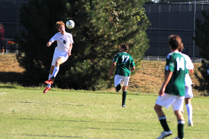 Senior Tyler Schwerdtfeger headbutts the ball in the second half of the game.