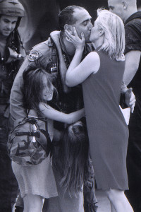 The VanZwoll family embraces after Sarah's father, Bill, arrives home from active duty.