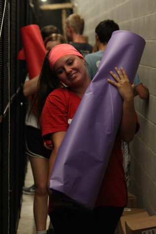 Senior StuGo representative Claire Albright carries a roll of paper to decorate during Homecoming spirit week.