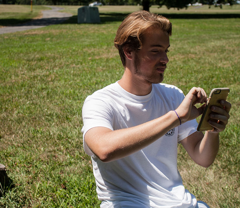 Senior Gage Hall catches a Pokemon at Heritage Park.